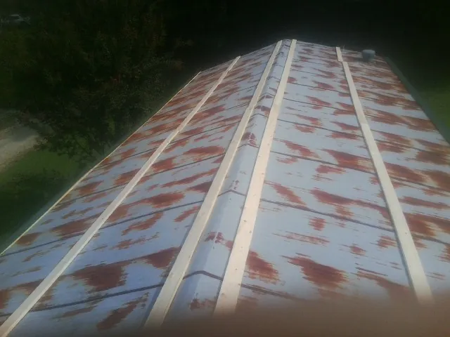 Rusted metal roof panels with new wood purlins before replacement — Storm Damage Roof Repair in Newington by Roofing Brothers